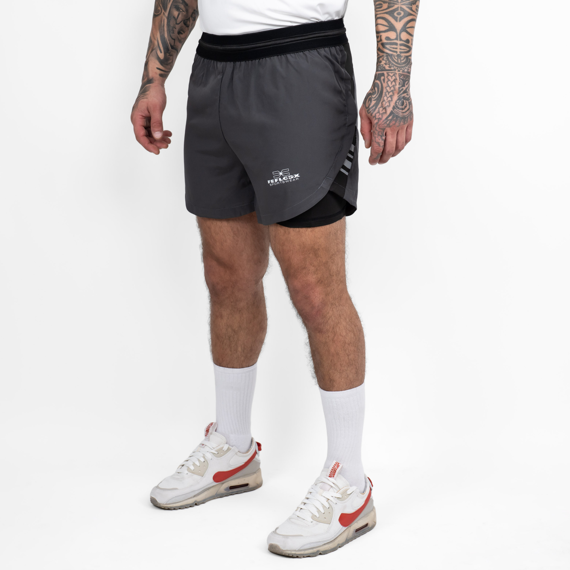 FFX 2 in 1 Performance Sport Shorts Fight Striker von FEFLOGX Sportswear, extrem hochwertige Gym Fight Shorts mit Tight Shorts, 2 in 1 Shorts, MMA Shorts, 2 in 1 Laufhose Herren, 2 in 1 Laufshorts in hellgrau, dunkelgrau & schwarz, seitliche Ansicht links vorne der dunkelgrauen Sportshorts. FFX 2 in 1 Performance Sport Shorts Fight Striker