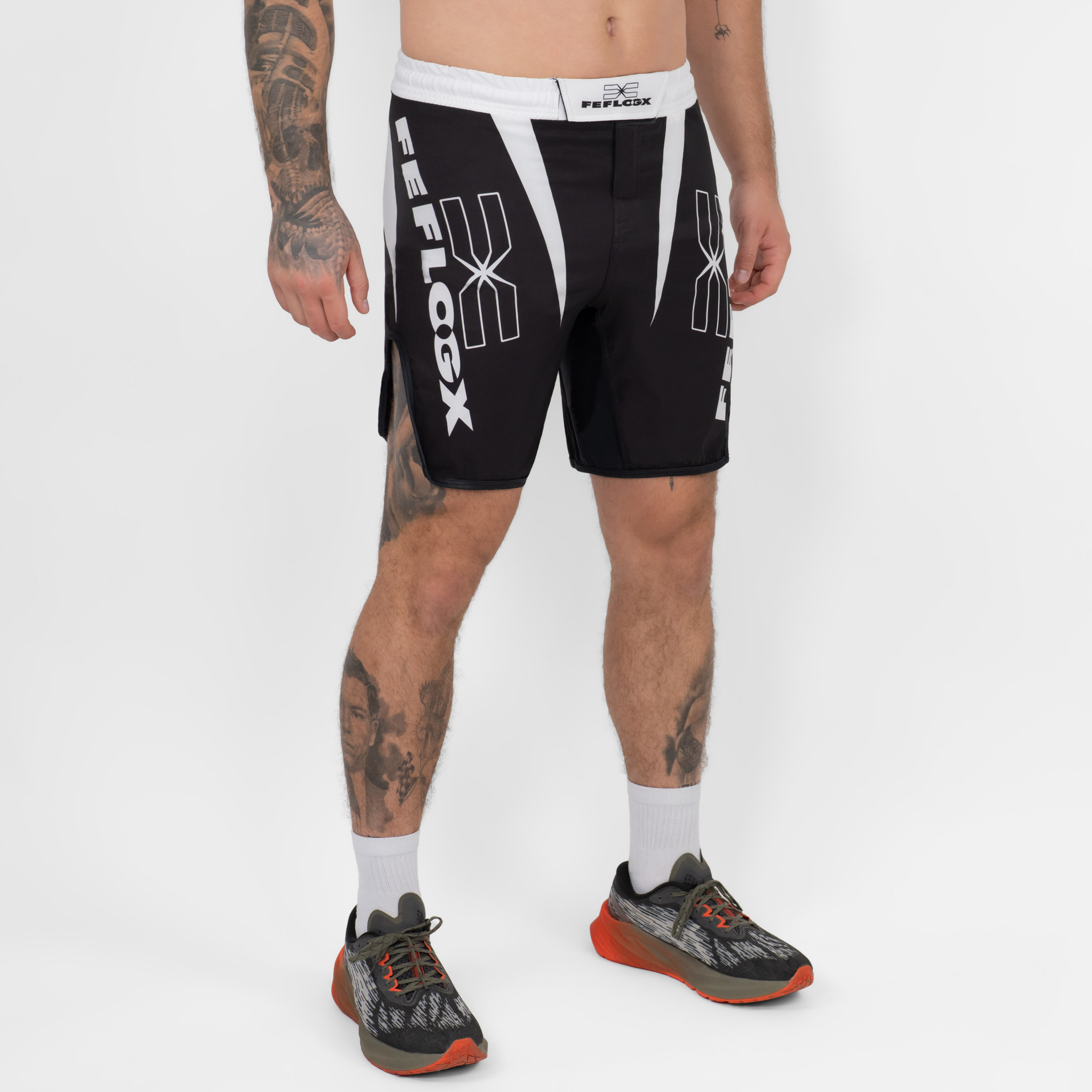 FFX Fight Shorts Competition Strength by FEFLOGX Sportswear, MMA Shorts für High Performance, Fight Shorts für Champions, Sport Shorts, MMA Hose Herren, Kickboxhosen, UFC Shorts, super komfortabel & mega Top Fighting-Design, Farben: schwarz, weiß, seitlich vordere Ansicht der schwarzen Fight Sport Shorts. FFX Fight Shorts Competition Strength