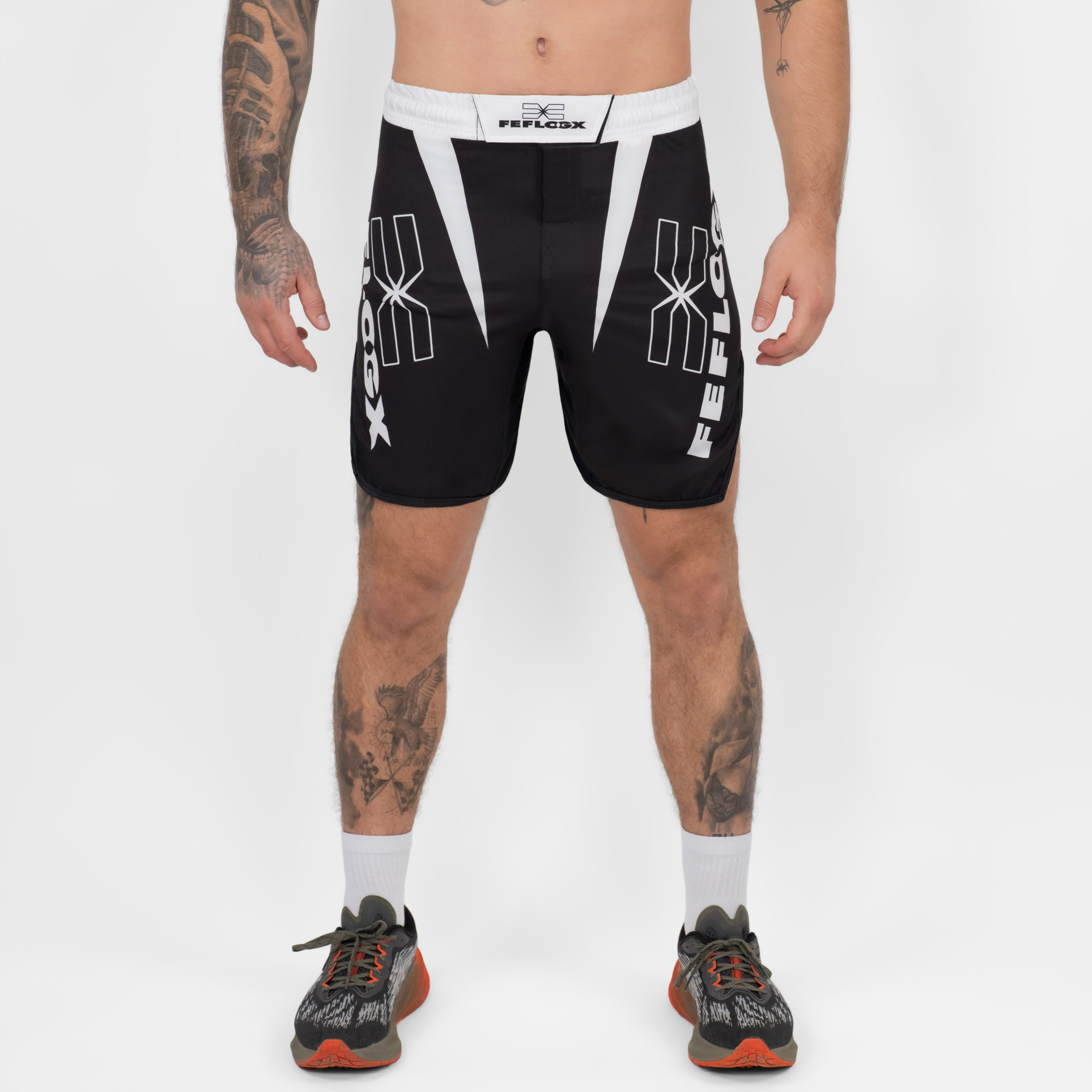 FFX Fight Shorts Competition Strength by FEFLOGX Sportswear, MMA Shorts für High Performance, Fight Shorts für Champions, Sport Shorts, MMA Hose Herren, Kickboxhosen, UFC Shorts, super komfortabel & mega Top Fighting-Design, Farben: schwarz, weiß, vordere Ansicht der schwarzen Fight Sport Shorts. FFX Fight Shorts Competition Strength