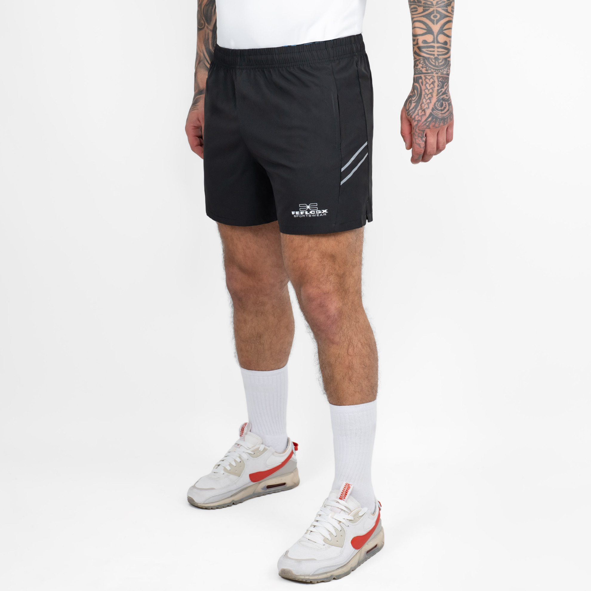 FFX Extra Kurze Sport Shorts High Power von FEFLOGX Sportswear, erstklassige Gym Shorts, super bequeme Laufshorts, Sporthose kurz Herren, kurze Jogginghose in grau & schwarz für Sport, Fitness & Kampfsport, seitliche Ansicht links vorne, schwarze Shorts. FFX Extra Kurze Sport Shorts High Power