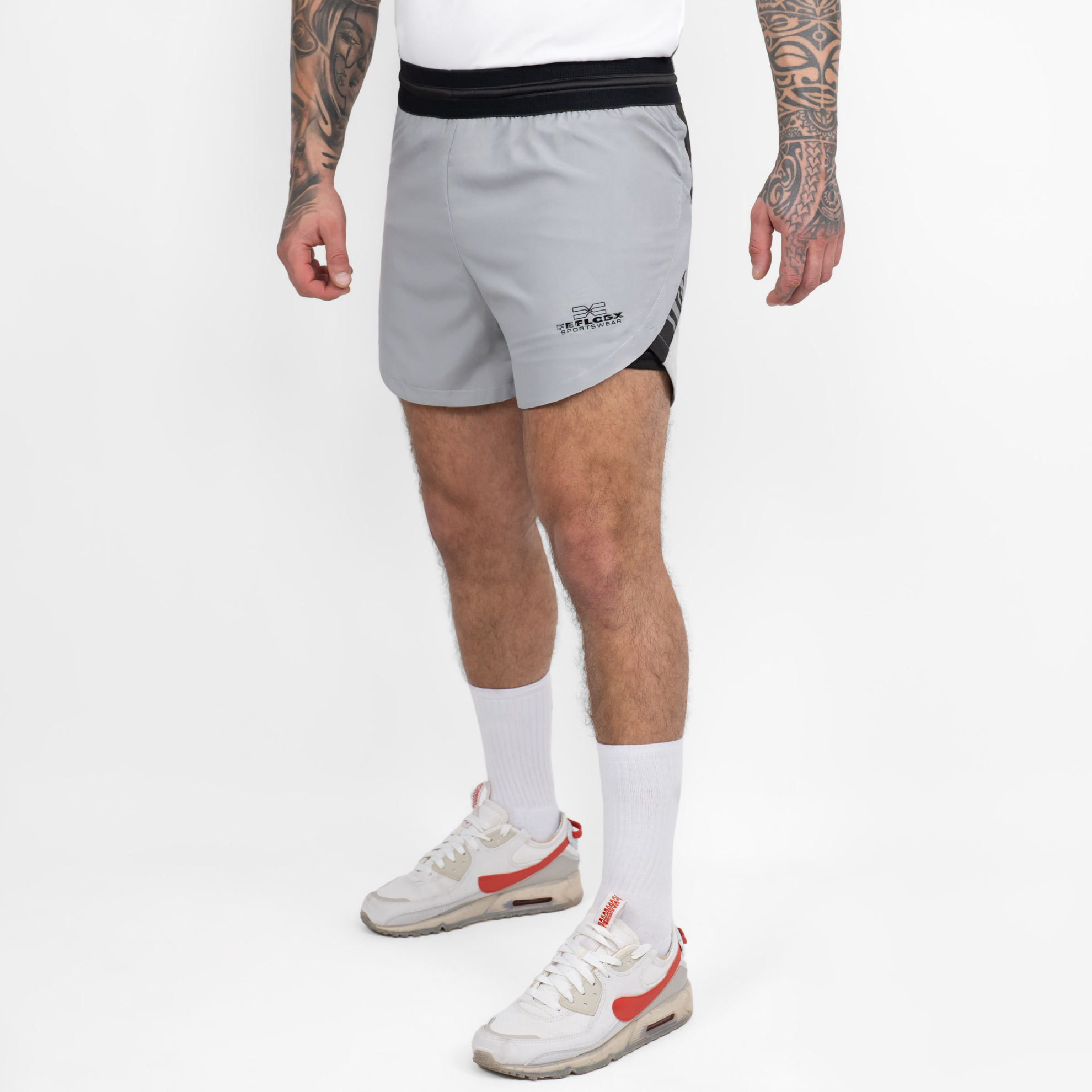 FFX 2 in 1 Performance Sport Shorts Fight Striker von FEFLOGX Sportswear, extrem hochwertige Gym Fight Shorts mit Tight Shorts, 2 in 1 Shorts, MMA Shorts, 2 in 1 Laufhose Herren, 2 in 1 Laufshorts in hellgrau, dunkelgrau & schwarz, seitliche Ansicht links vorne der hellgrauen Sportshorts. FFX 2 in 1 Performance Sport Shorts Fight Striker