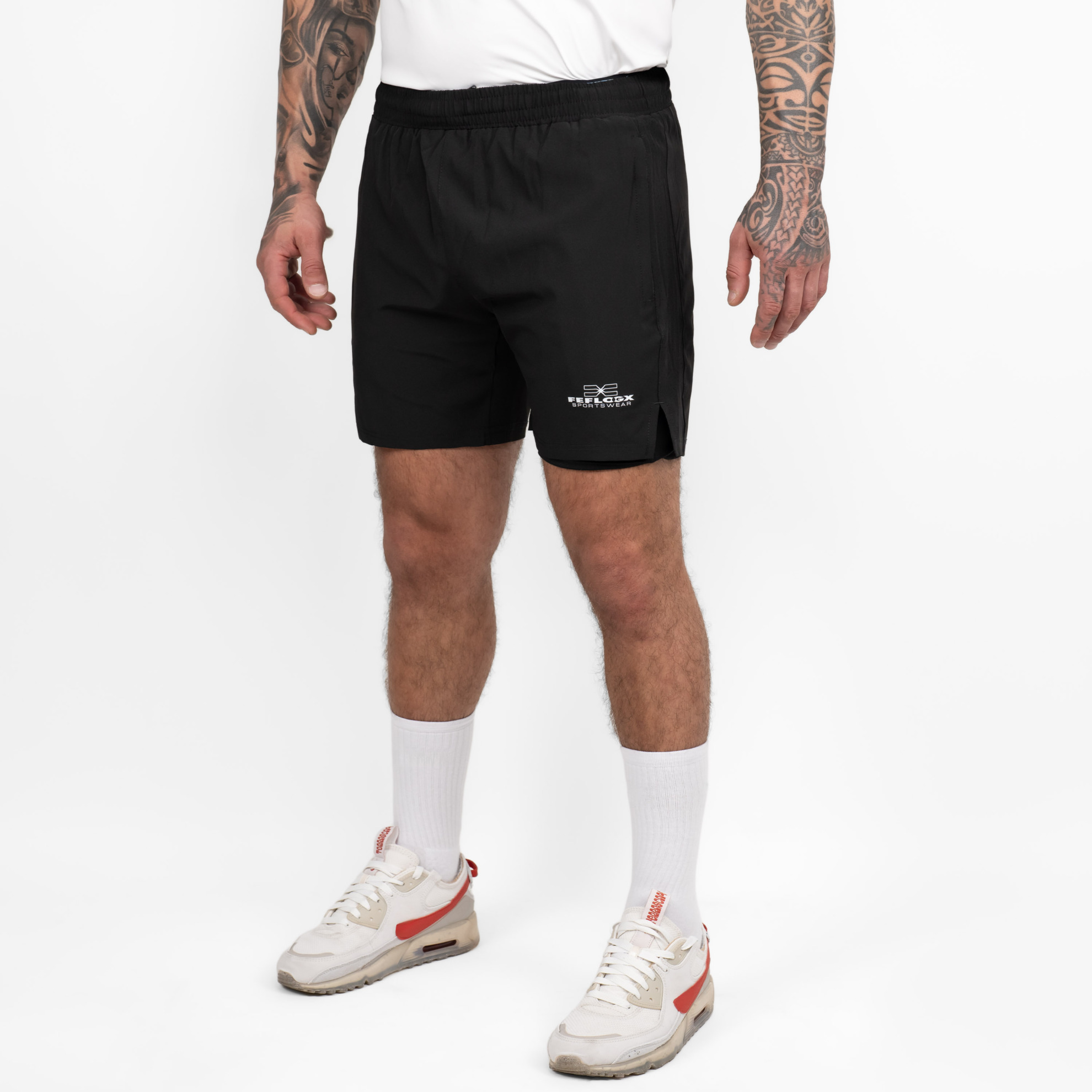 FFX 2-in-1 Superior Sport Shorts mit Tights von FEFLOGX Sportswear, extrem hochwertige kurze Jogginghose, kurze Sporthose mit Tight Shorts, 2 in 1 Shorts Herren, MMA Shorts, 2 in 1 Laufhose Herren, 2 in 1 Laufshorts Herren in grau & schwarz, seitliche Ansicht links vorne der schwarzen Sportshorts. FFX 2-in-1 Superior Sport Shorts mit Tights