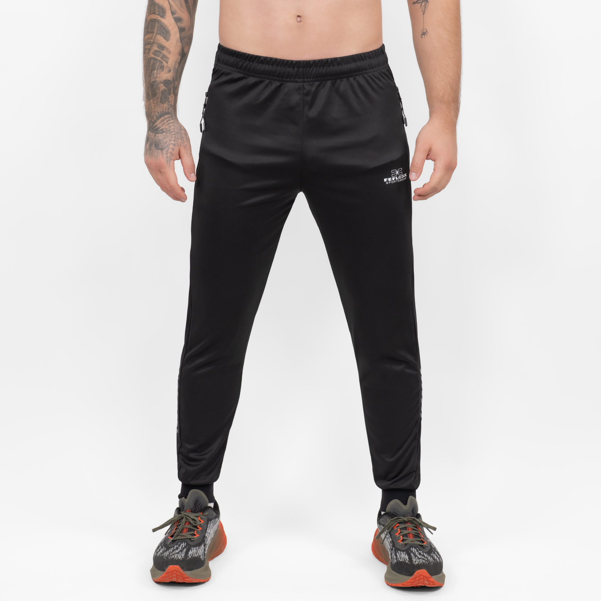 FFX High Performance Trainingshose Fighting Fitness by FEFLOGX Sportswear, Teil des Trainingsanzug: FFX Superior Jogginganzug Absolute Power, Top-Style Trainingshose Herren, Track Pants mit super bequemer Passform, Sporthose mit Handytasche, Herren Jogginghose, Top Jogger, Sport Hose für High Performance, Farben: schwarz, vordere Ansicht der schwarzen Jogging Hose mit Reißverschlusstaschen. FFX High Performance Trainingshose Fighting Fitness